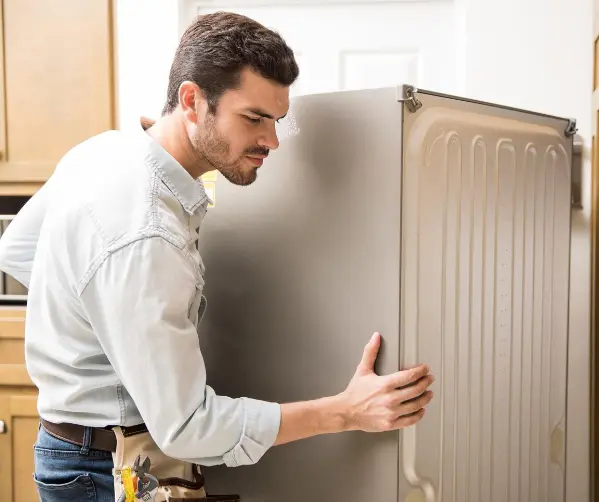 Appliance repair technician giving honest refrigerator repair advice to a homeowner