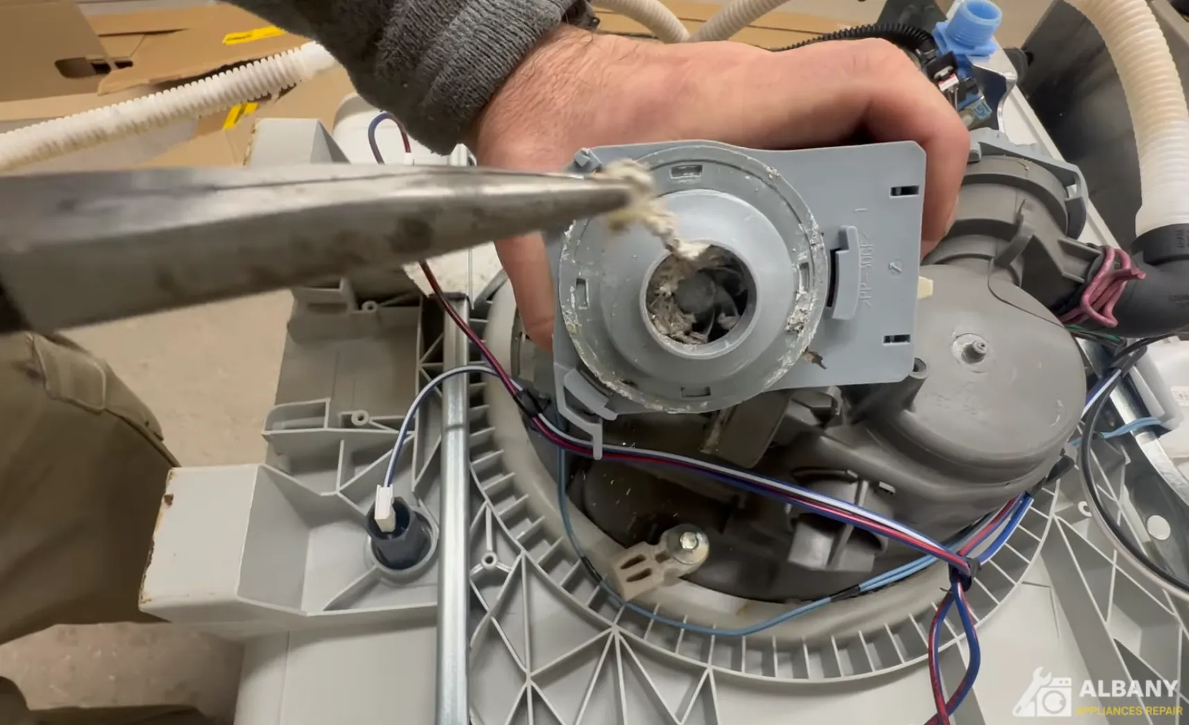 Person repairing dishwasher motor component