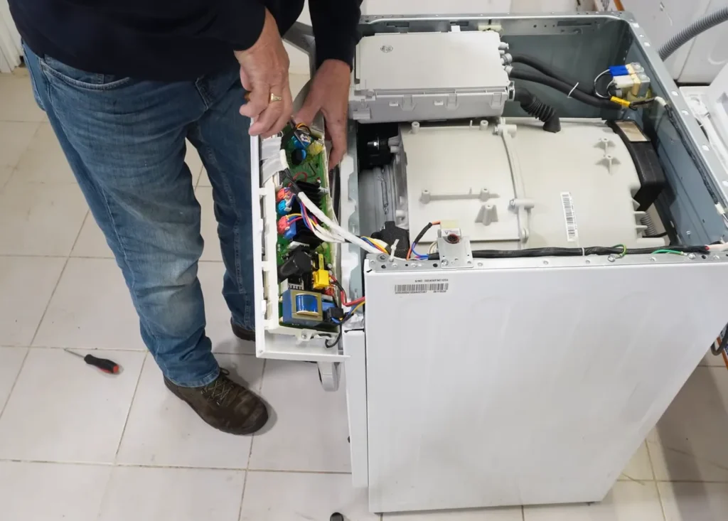 technician repairing washing machine control board